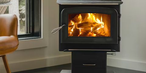 Wood-burning fireplace beside a leather armchair